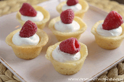 These raspberry sugar cookie cups are as delicious as they are adorable! Filled with cream and topped with a berry, they're simple as can be! #recipes #dessert #raspberrysugarcookiecups #raspberrydessert www.orsoshesays.com