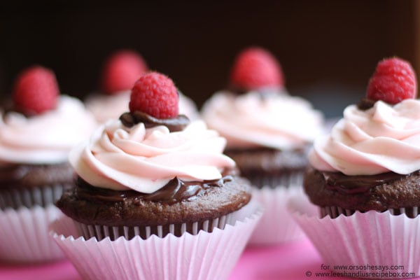 Perfect for Valentine's Day, these decadent chocolate cupcakes are topped with ganache and raspberry buttercream frosting. Get the recipe on the blog today! www.orsoshesays.com