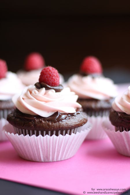 Perfect for Valentine's Day, these decadent chocolate cupcakes are topped with ganache and raspberry buttercream frosting. Get the recipe on the blog today! www.orsoshesays.com